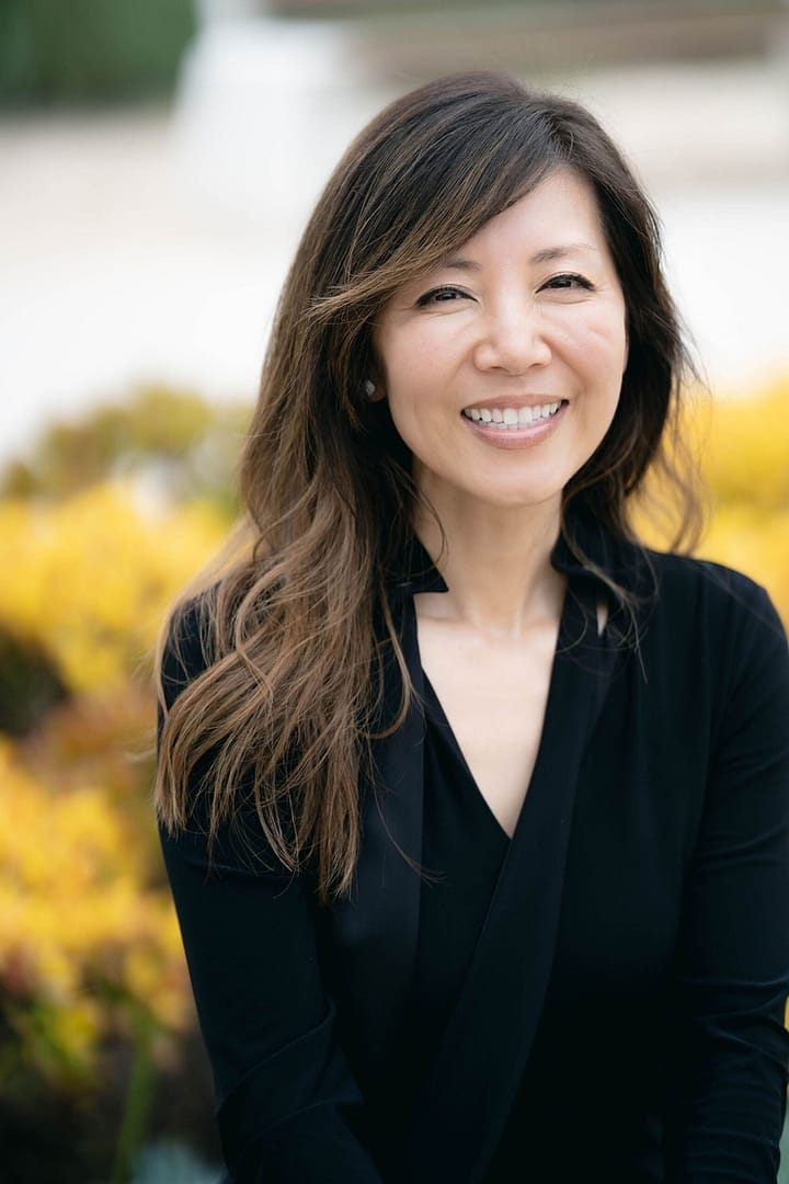 A woman in black shirt smiling for the camera.